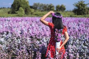 volwassen Aziatische reizen vrouw staan ontspannen in margaret bloem veld. foto