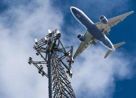 5g mobiele telefoon of mobiele servicetoren met vliegtuigen die naderen om te landen foto