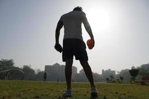 man bij stedium over het silhouetbeeld met schudfles voor gymnastiek en het drinken van gainer - fysiek fitnessconcept foto