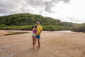 volwassen paar staande op het strand bekend als taipe in de buurt van arraial d ajuda, biaha, brazilië foto