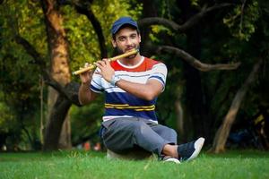 jongen die bansuri-fluit indisch blaasinstrument speelt foto