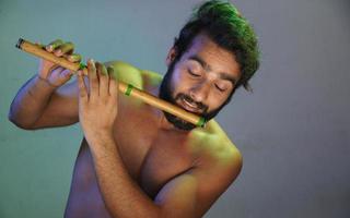 jonge man die hartstochtelijk fluit speelt zonder doeken studio-opname foto