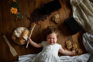 kleine meisjeskok met een houten lepel bereidt de lunch voor. foto