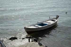 enkele boot op zand met zee tussen cirkel fecne en uitzicht op het strand met andere foto