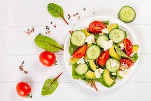 bovenaanzicht, salade met verse kruiden, gesneden groenten en kwark foto
