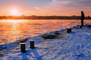 mensen op de pier kijken naar de zonsondergang foto