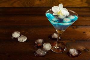 blauwe cocktail geserveerd met orchidee foto