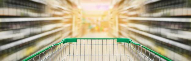 winkelwagentje met wijnflessenplanken in het gangpad van de supermarkt foto