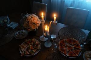 een gedekte tafel met brandende kaarsen, een romantisch diner foto