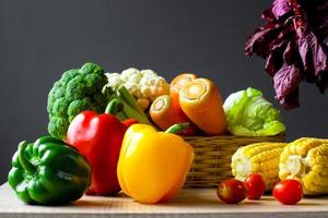 verschillende van verse kleurrijke groenten op houten tafel foto