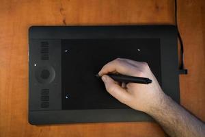 de ontwerper tekent in close-up op een grafisch tablet foto