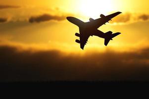 silhouet van een passagiersvliegtuig dat 's avonds opstijgt vanaf de luchthaven. foto