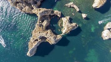 luchtfoto drone shot van kajaks en boten die rond de magische kalkstenen kliffen van ponta da piedade varen. het verkennen van grotten en tunnels van Lagos, Algarve, ten zuiden van Portugal. reizen en avontuur. nomaden leven. foto