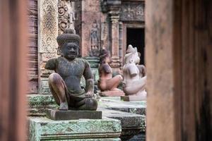 de demon standbeeld bewaker van de oude ruïnes banteay srei de prachtige roze zandsteen tempel in het oude khmer koninkrijk, naad oogsten, cambodja. foto
