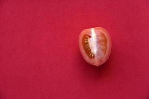 sappige tomaat op een rode achtergrond foto