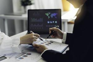 zakelijke teamvergadering aanwezig, investeerderscollega's bespreken nieuwe financiële grafiekgegevens van plannen op kantoortafel met laptop, financiën, boekhouding, investeringen. foto