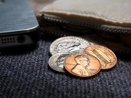 Amerikaanse dollarmunten die met smartphone buiten de portemonnee zijn geplaatst. foto