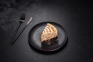 esterhazy cake gesneden op zwarte plaat close-up. delicatessen zoet dessert met amandel meringue deeg en botercrème foto