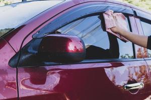 auto detaillering - de man houdt de microvezel in de hand en poetst de auto. selectieve aandacht. foto