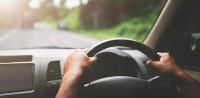 close-up handbestuurder auto op weg met zonneschijn foto