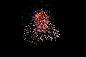 kleurrijk vuurwerk tegen een zwarte nacht sky.fireworks voor het nieuwe jaar. prachtig kleurrijk vuurwerk op het stedelijke meer om te vieren op een donkere nachtachtergrond. foto