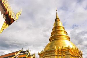 gouden pagode en naga decoratie dak tempel thai foto