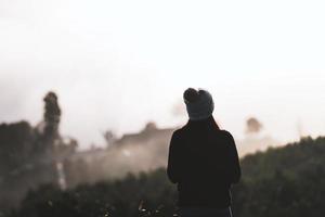 silhouet achteraanzicht volwassen vrouw solo reiziger ontspannen in de natuur van zonsopgang in de ochtend met mist. foto