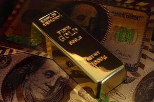 een gouden staaf met dollar achtergrond. conceptueel beeld of gouden investering. foto