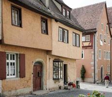 rothenburg ob der tauber, noord-beieren, duitsland, 2014. man loopt langs een pittoreske straat foto