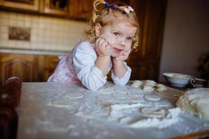 bakkersmeisje in koksmuts in de keuken foto
