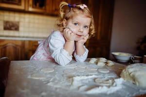 bakkersmeisje in koksmuts in de keuken foto