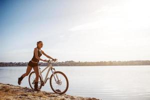 vrouw op een fiets bij het water foto