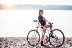vrouw op een fiets bij het water foto
