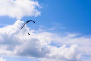 man aan een parachute die in de heldere lucht vliegt foto