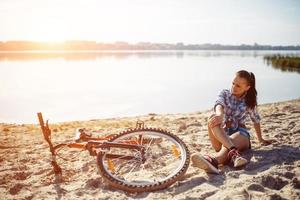 vrouw op een fiets op het strand foto