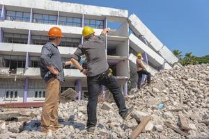 ingenieursteam en werknemer controleren blauwdruk op bouwplan voor emolition en inspecteren op de locatie. foto