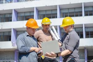 ingenieursteam en werknemer controleren blauwdruk op bouwplan voor emolition en inspecteren op de locatie. foto