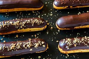 traditionele franse eclairs met chocolade. lekker toetje. zelfgemaakte cake-eclairs. zoet dessertdeeg gevuld met room. chocolade glazuur. foto