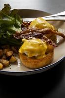 Eggs Benedict bacon ontbijt op tafel foto