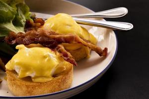 Eggs Benedict bacon ontbijt op tafel foto