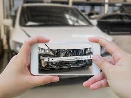 vrouwelijke greep mobiele smartphone die auto-ongeluk fotografeert foto