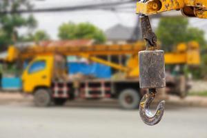 kranenhaken die over de achtergrond van de kraanwagen hangen foto