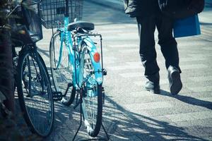 Kyoto, Japan, in de ochtend, een man met een papieren zak passeerde een fiets tijdens het lopen foto