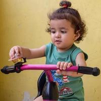 schattige kleine jongen shivaay fietsen op het balkon thuis tijdens de zomer, lieve kleine jongen fotoshoot overdag, kleine jongen geniet van fietsen thuis tijdens fotoshoot foto