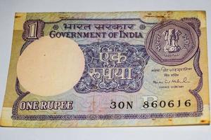 zeldzame oude Indiase roepie munt biljet op witte achtergrond, regering van india één roepie oude bankbiljet Indiase valuta, oude Indiase valuta biljet op tafel foto