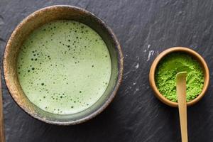 groene matcha-thee bereidt zich voor op steenzwarte tafel foto