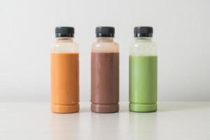 chocolade, thaise melkthee en matcha groene thee in plastic fles foto