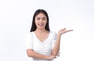Aziatische mooie vrouw met zwart lang haar, gekleed in een wit overhemd en mooie glimlach is aanwezig product op witte achtergrond. foto