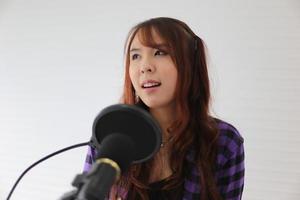 portret jonge vrouw zingen op microfoon, close-up shot. foto