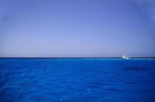 blauw zeewater en schip bij koraalrif foto